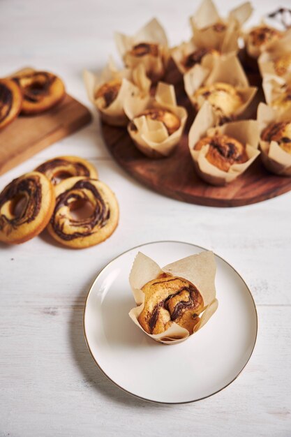 Ripresa verticale ad alto angolo di deliziosi muffin al cioccolato e ciambelle su un tavolo bianco