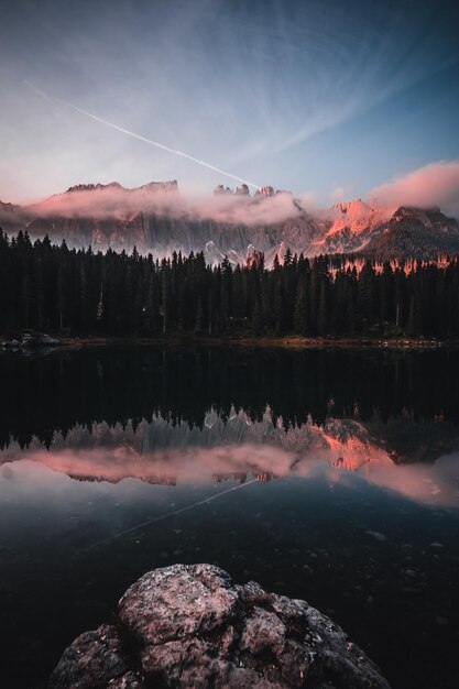 Ripresa verticale del Lago di Carezza circondato dalle Dolomiti e dal verde in Alto Adige Italia