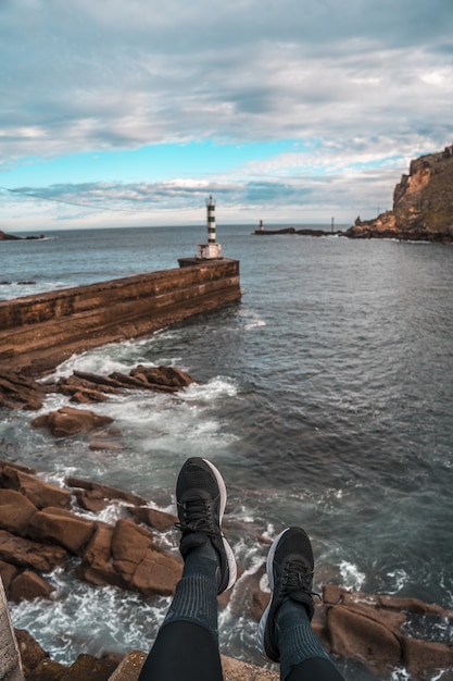 Ripresa verticale di un faro su un molo di pietra a Pasajes San Pedro, Gipuzkoa, Spagna