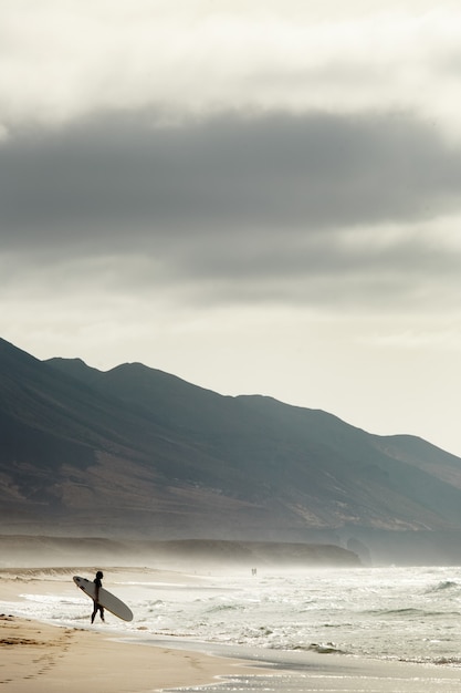 Ripresa verticale di un surfista su una spiaggia di Cofete, Fuerteventura, Isole Canarie