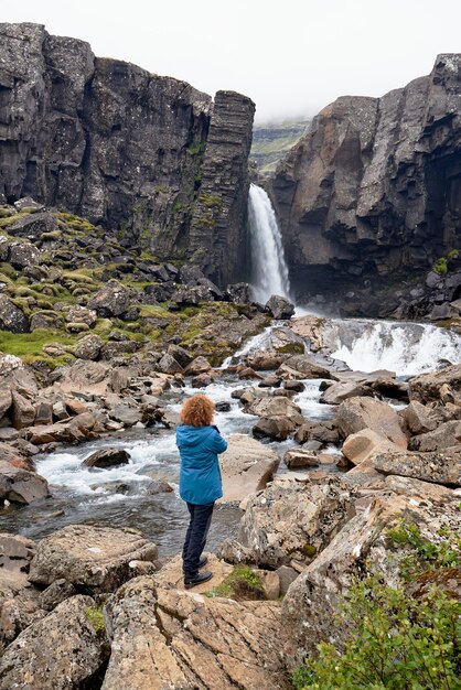 Ripresa verticale di una donna che scatta una foto della baia di Breidafjordur in Islanda