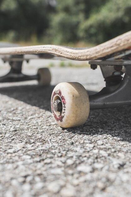 Ripresa verticale di uno skateboard a terra sotto la luce del sole