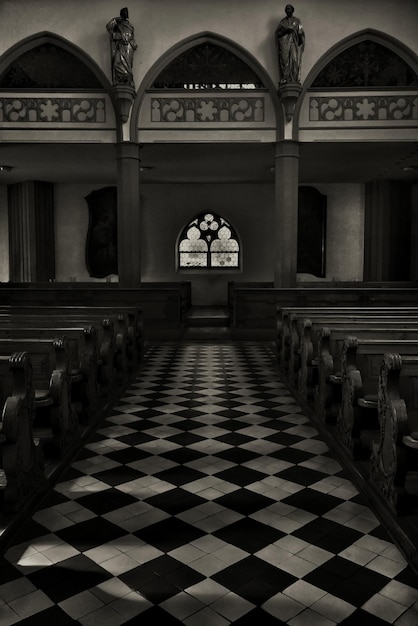 Ripresa verticale in scala di grigi dell'interno di una bella chiesa storica ripresa dal lato dell'altare