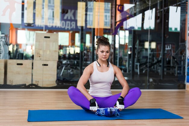 Riscaldamento della donna sulla stuoia di yoga