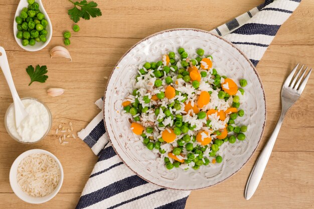 Riso con i fagiolini e la carota sul piatto vicino a salsa in ciotola sul tavolo
