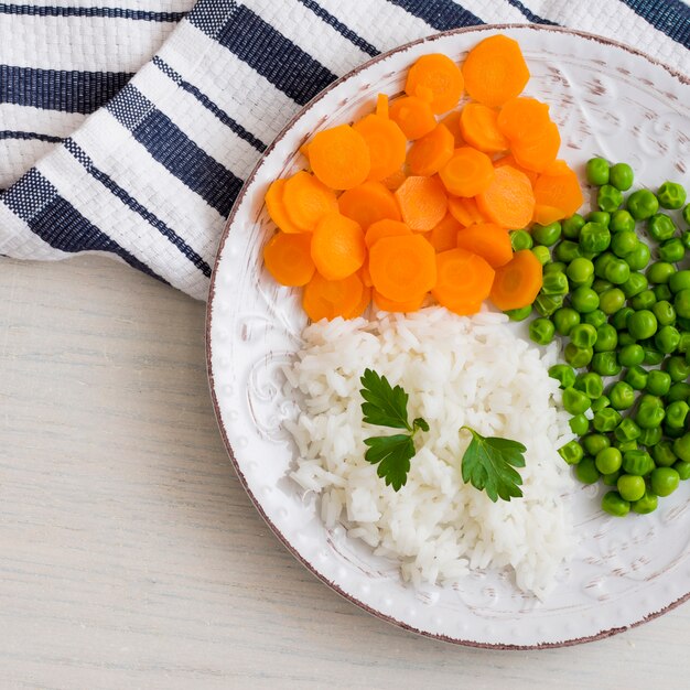 Riso con verdure e prezzemolo sul piatto bianco