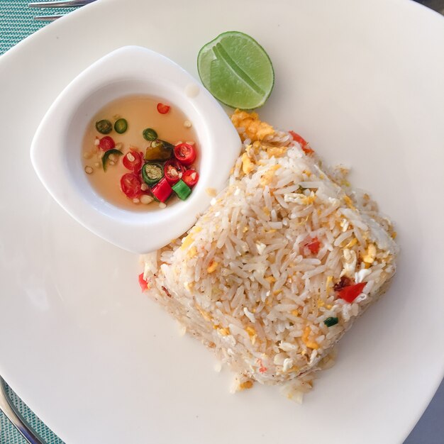 Riso fritto asiatico con uova, mais e prezzemolo close-up su un piatto, vista orizzontale dall&#39;alto