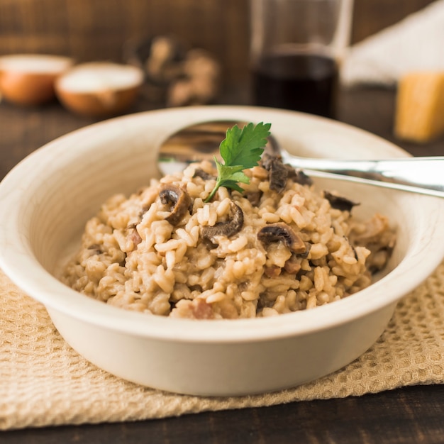 Risotto ai funghi delizioso in una ciotola bianca con un cucchiaio