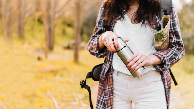 Ritaglia la donna con il thermos di chiusura della mappa