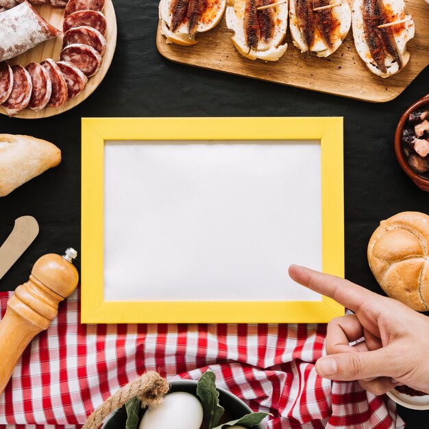 Ritaglia la mano che punta al fotogramma vuoto in mezzo al cibo