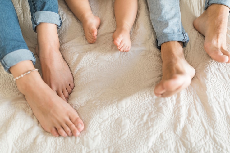 Foto gratuito ritaglia le gambe della famiglia sul letto