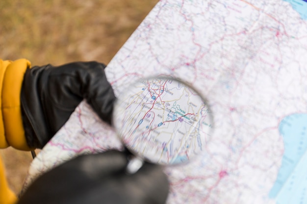 Ritaglia le mani con la mappa di lettura della lente d&#39;ingrandimento