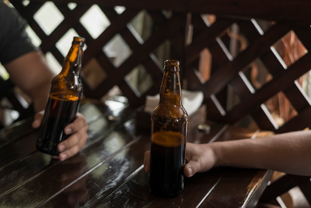 Ritaglia le mani tenendo la birra sul tavolo