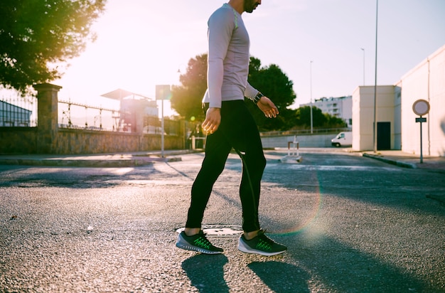 Ritaglia lo sportivo camminando sulla strada