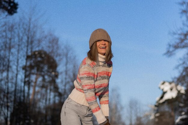 Ritratto all'aperto di giovane bella donna sorridente felice alla moda inverno ritratto, donna in cappello invernale, neve. godersi i momenti invernali