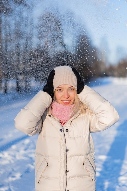 Ritratto all'aperto di giovane bella donna sorridente felice alla moda inverno ritratto, donna in cappello invernale, neve. godersi i momenti invernali