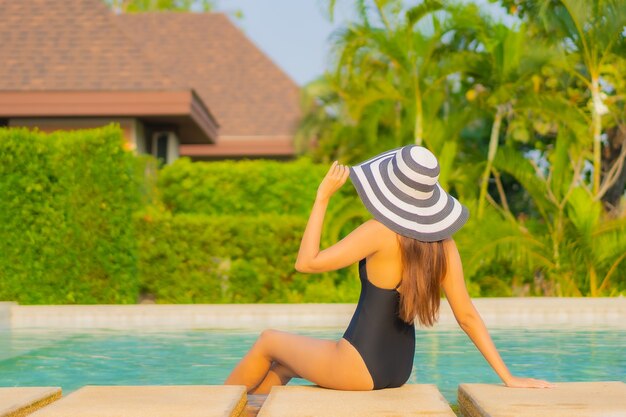 Ritratto bella giovane donna asiatica che si rilassa intorno alla piscina in hotel resort in vacanza