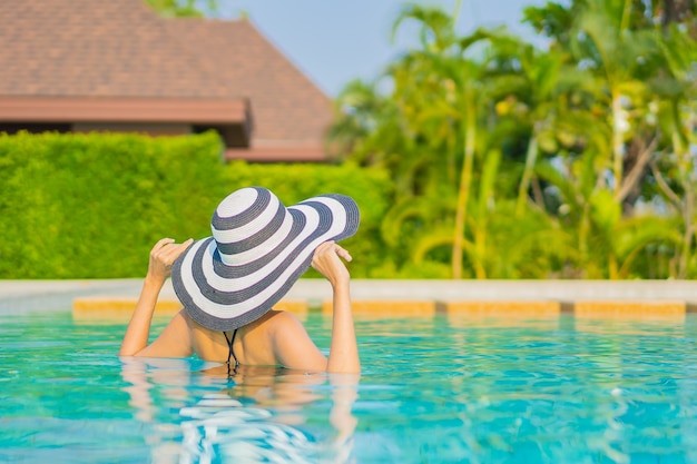 Ritratto bella giovane donna asiatica che si rilassa intorno alla piscina in hotel resort in vacanza