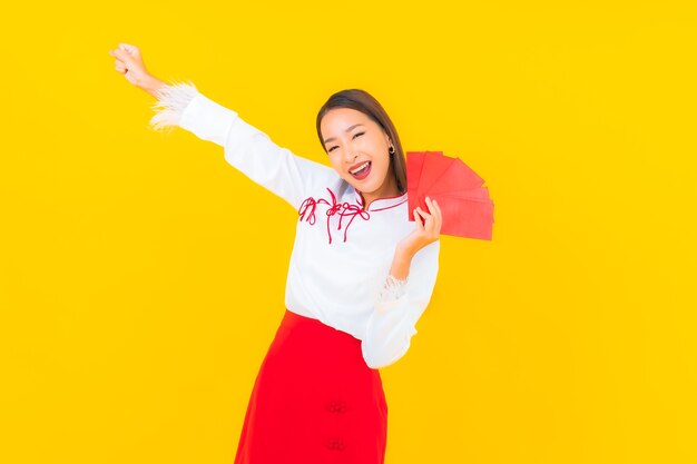 Ritratto bella giovane donna asiatica con buste rosse lettera nel capodanno cinese su yellow