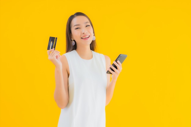Ritratto bella giovane donna asiatica con carta di credito per lo shopping online