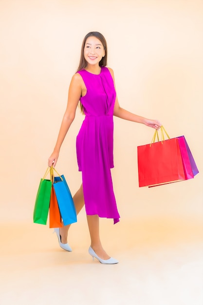 Ritratto bella giovane donna asiatica con la borsa della spesa su sfondo di colore isolato