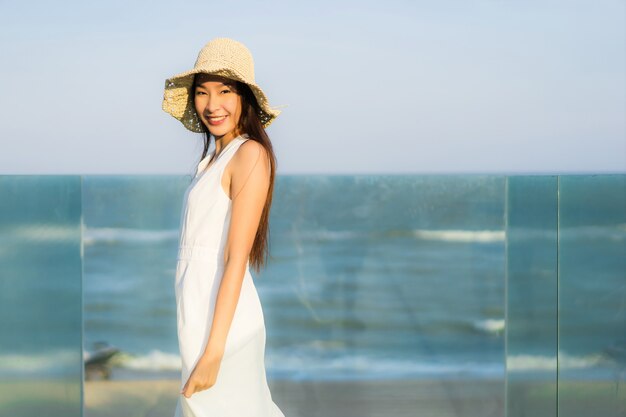 Ritratto bella giovane donna asiatica felice e sorriso sulla spiaggia mare e oceano