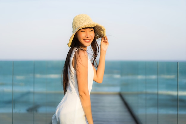 Ritratto bella giovane donna asiatica felice e sorriso sulla spiaggia mare e oceano