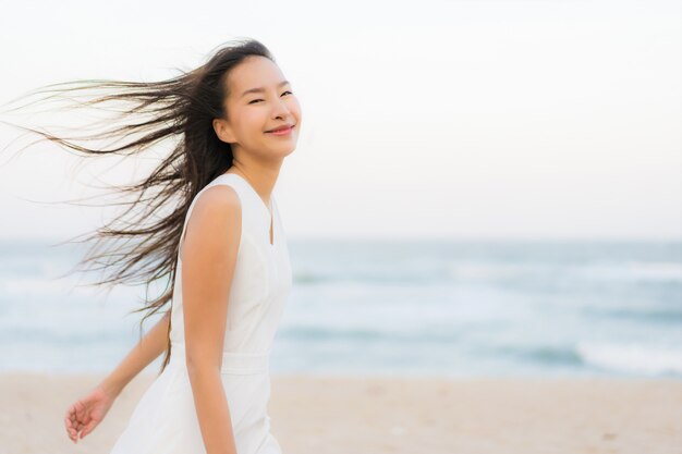 Ritratto bella giovane donna asiatica felice e sorriso sulla spiaggia mare e oceano