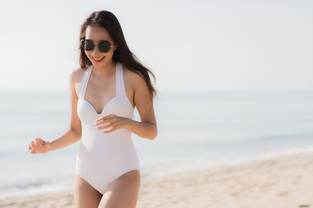 Ritratto bella giovane donna asiatica felice e sorriso sulla spiaggia mare e oceano