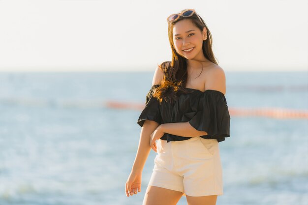 Ritratto bella giovane donna asiatica felice e sorriso sulla spiaggia mare e oceano