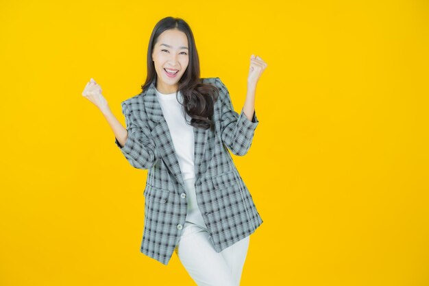 Ritratto bella giovane donna asiatica sorriso con azione su sfondo a colori