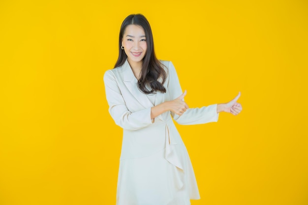 Ritratto bella giovane donna asiatica sorriso con azione su sfondo colorato