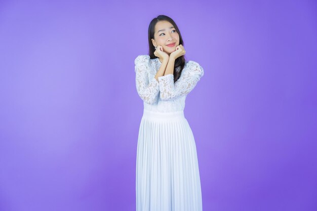 Ritratto bella giovane donna asiatica sorriso con azione su sfondo colorato