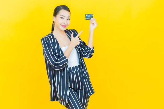 Ritratto bella giovane donna asiatica sorriso con carta di credito su sfondo a colori