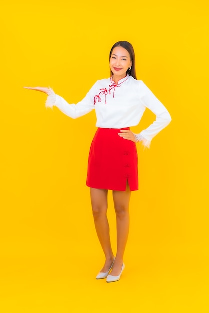 Ritratto bella giovane donna asiatica sorriso in azione su yellow