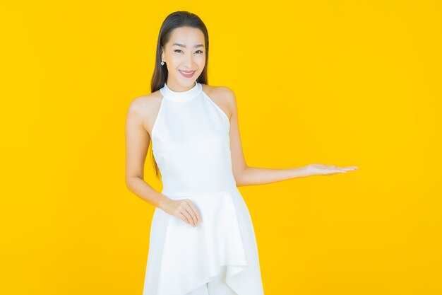 Ritratto bella giovane donna asiatica sorriso su yellow