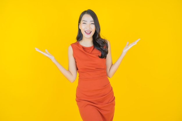 Ritratto bella giovane donna asiatica sorriso su yellow