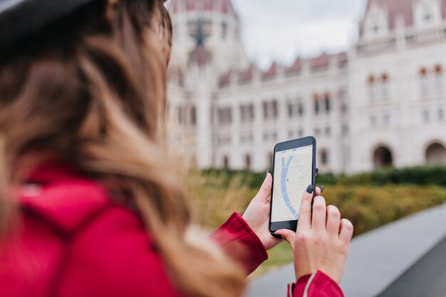 Ritratto dal retro di una donna dai capelli scuri che utilizza il GPS durante il viaggio