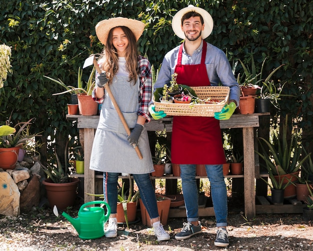 Ritratto degli strumenti di tenuta del giardiniere e del cestino maschii e femminili nel giardino