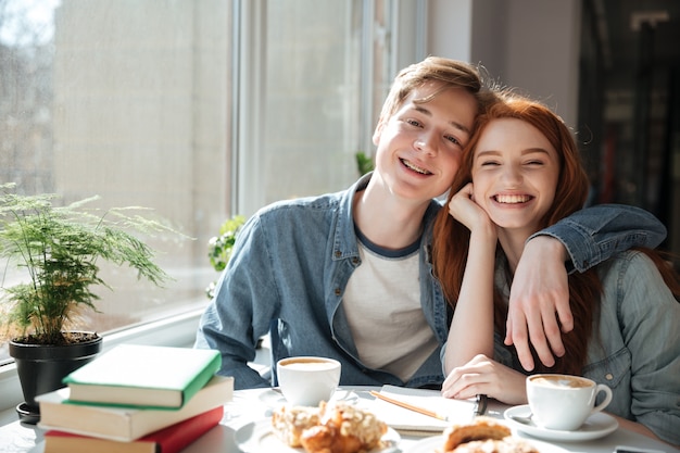 Ritratto degli studenti che abbracciano nel caffè