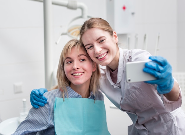 Ritratto del dentista che prende un selfie con il paziente