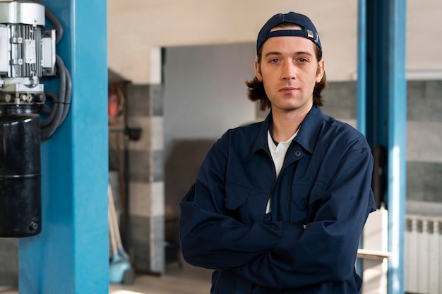 Ritratto del meccanico di automobile maschio nell'officina di riparazione dell'automobile