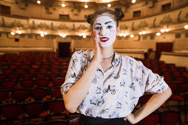 Ritratto del mimo femminile premuroso che sta in un auditorium