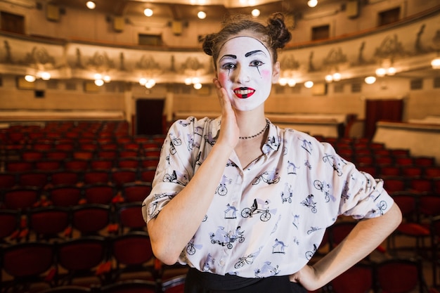 Ritratto del mimo femminile premuroso che sta in un auditorium