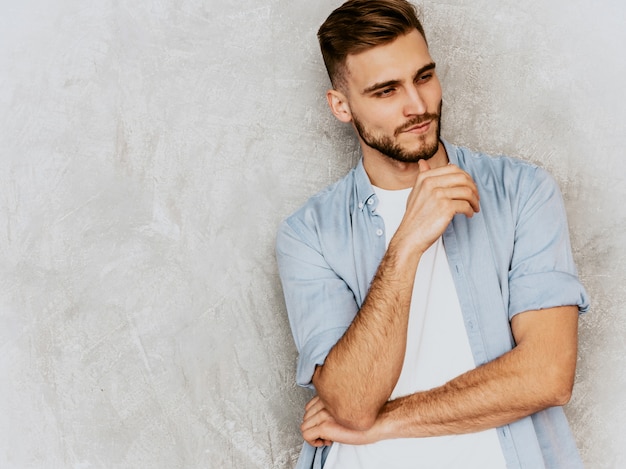 Ritratto del modello bello del giovane che indossa i vestiti casuali della camicia. Posa alla moda dell'uomo di modo