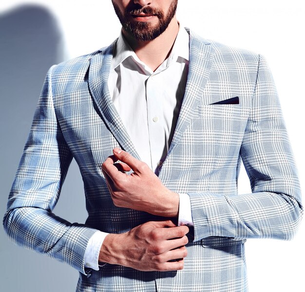 ritratto del modello di uomo d'affari alla moda hipster alla moda bello vestito in elegante abito azzurro in bicchieri su bianco