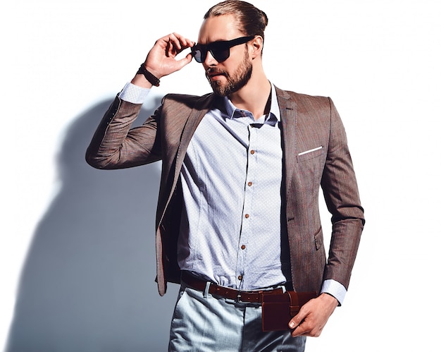 ritratto del modello di uomo d'affari alla moda hipster alla moda bello vestito in elegante abito marrone in occhiali da sole