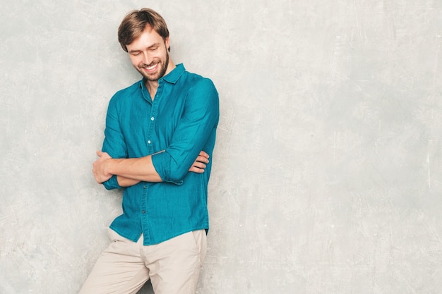 Ritratto del modello di uomo d'affari lumbersexual hipster sorridente bello che indossa i vestiti casuali della camicia dei jeans.