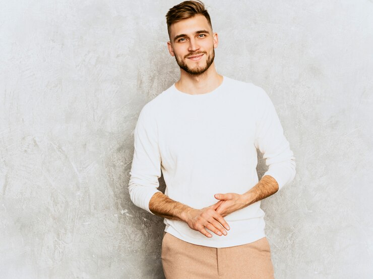 Foto gratuito ritratto del modello sorridente bello dell'uomo d'affari dei pantaloni a vita bassa che indossa i vestiti bianchi casuali di estate.