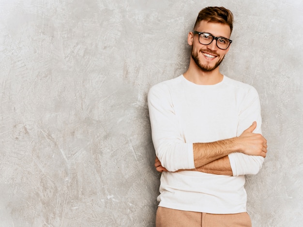 Ritratto del modello sorridente bello dell'uomo d'affari dei pantaloni a vita bassa che indossa i vestiti bianchi casuali di estate.